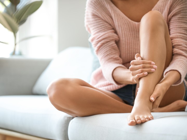 woman holding leg and ankle in pain