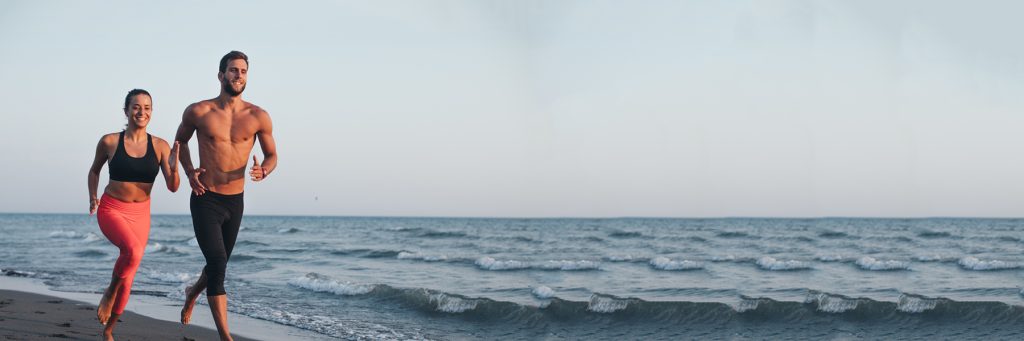 couple running along a beach