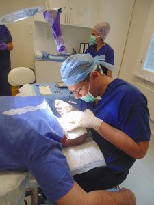 A hair transplant surgeon performing a hair transplant procedure